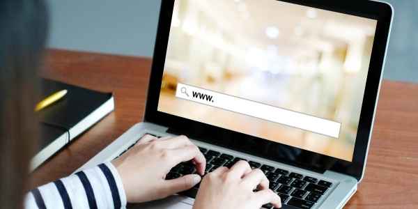 A close-up of a laptop screen with a woman starting an internet search